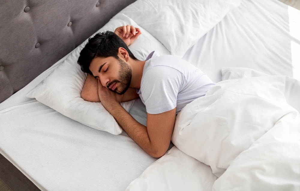 Un homme sommeille dans un lit.