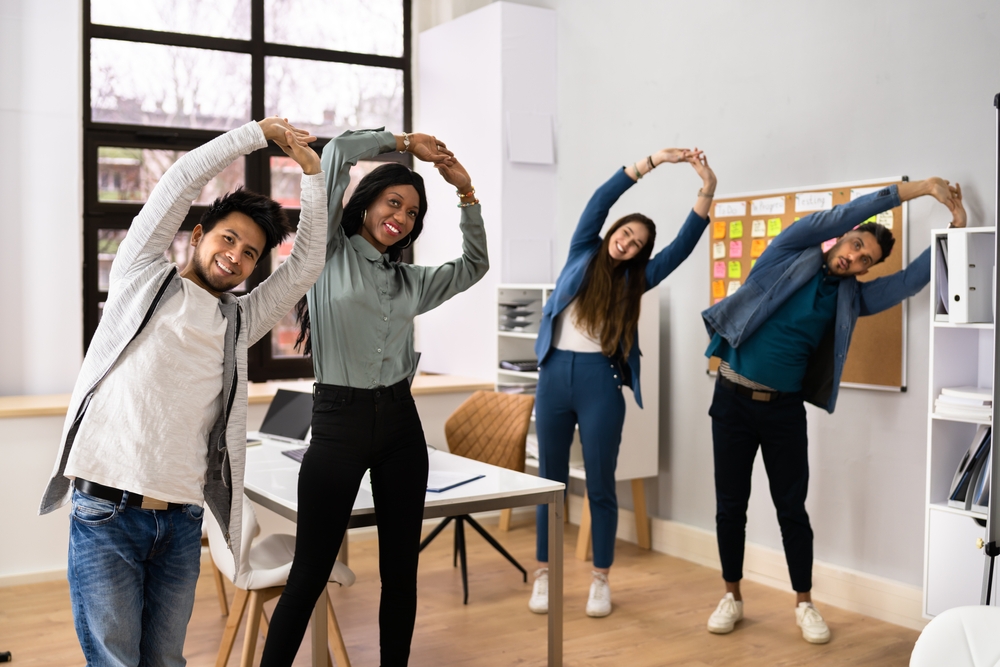 A group of office workers doing yoga.