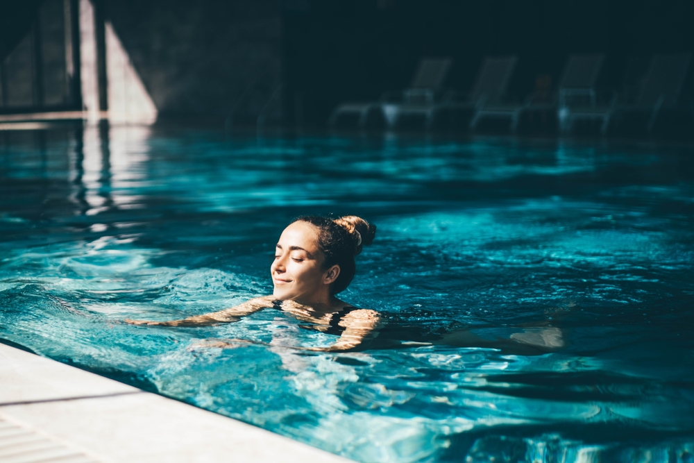 A woman swimming in an indoor pool.