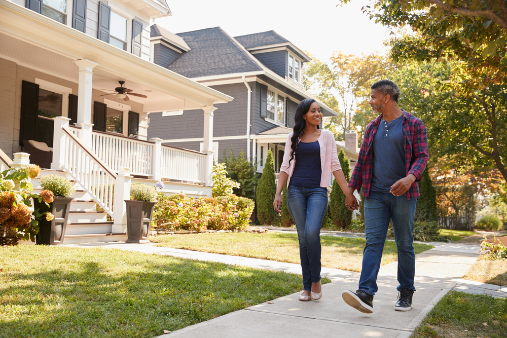A man and woman walking in a suburban neighbourhood. A man and woman walking in a suburban neighbourhood.