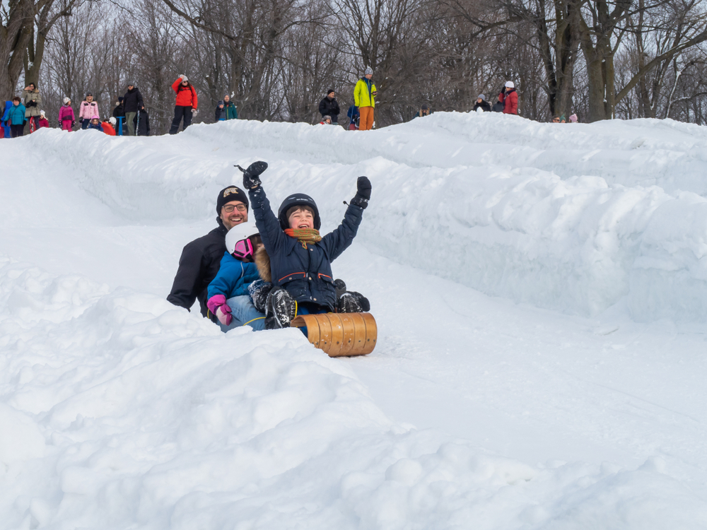 Un père et ses deux enfants faisant de la luge. Un père et ses deux enfants faisant de la luge.