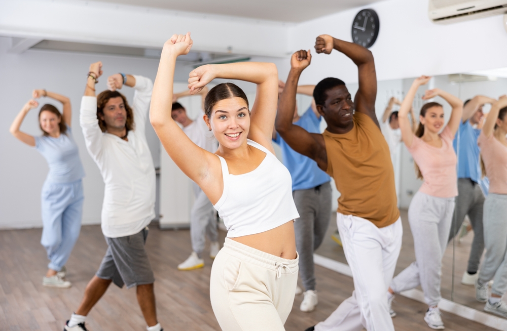Un groupe de personnes dansant ensemble dans un studio. Un groupe de personnes dansant ensemble dans un studio.