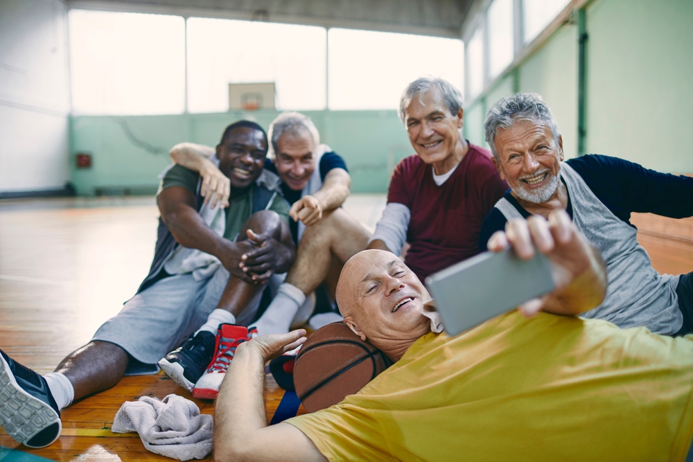 Un groupe d’hommes âgés prend un égoportrait sur un terrain de basketball. Un groupe d’hommes âgés prend un égoportrait sur un terrain de basketball.