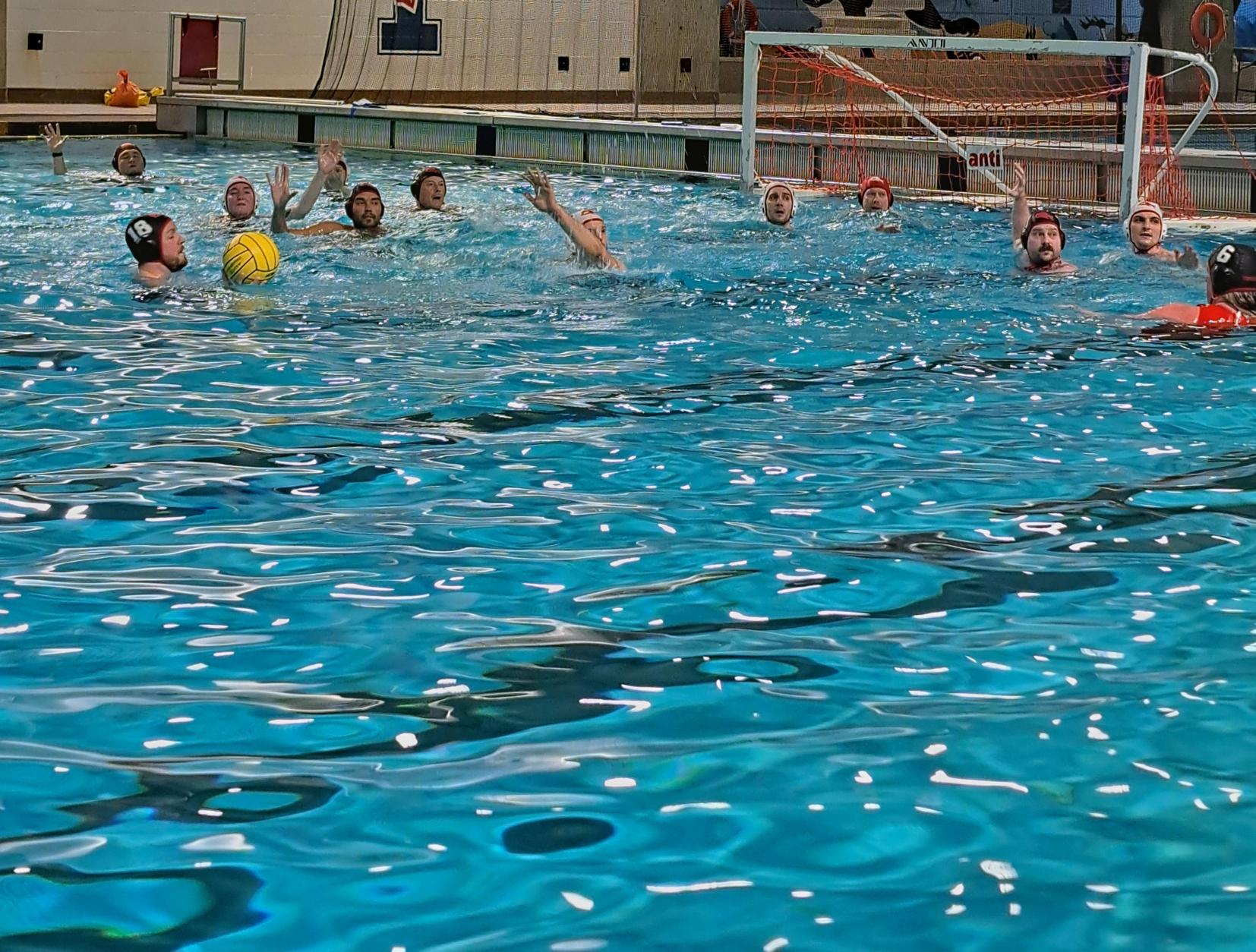 Des personnes jouent au water-polo dans une piscine intérieure. Des personnes jouent au water-polo dans une piscine intérieure.