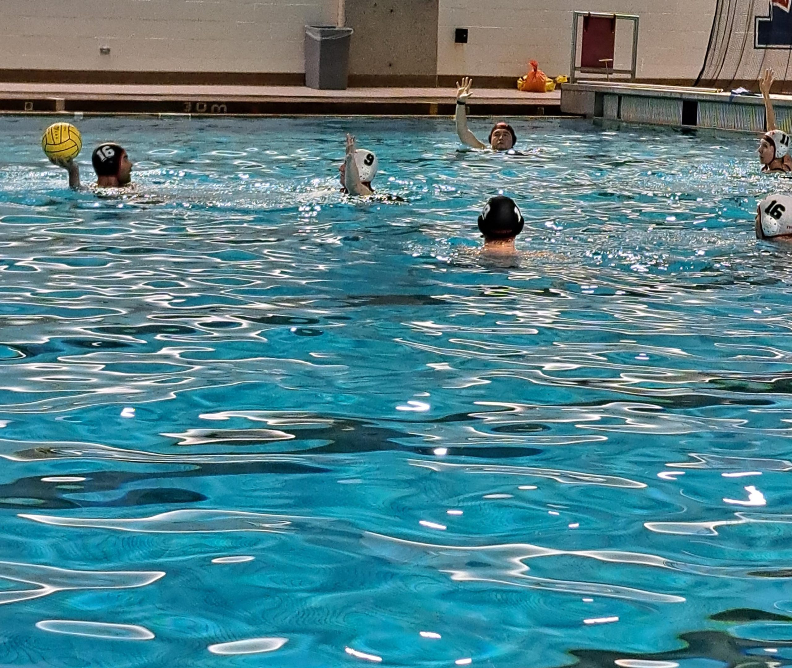 Des personnes jouent au water-polo dans une piscine intérieure. Des personnes jouent au water-polo dans une piscine intérieure.