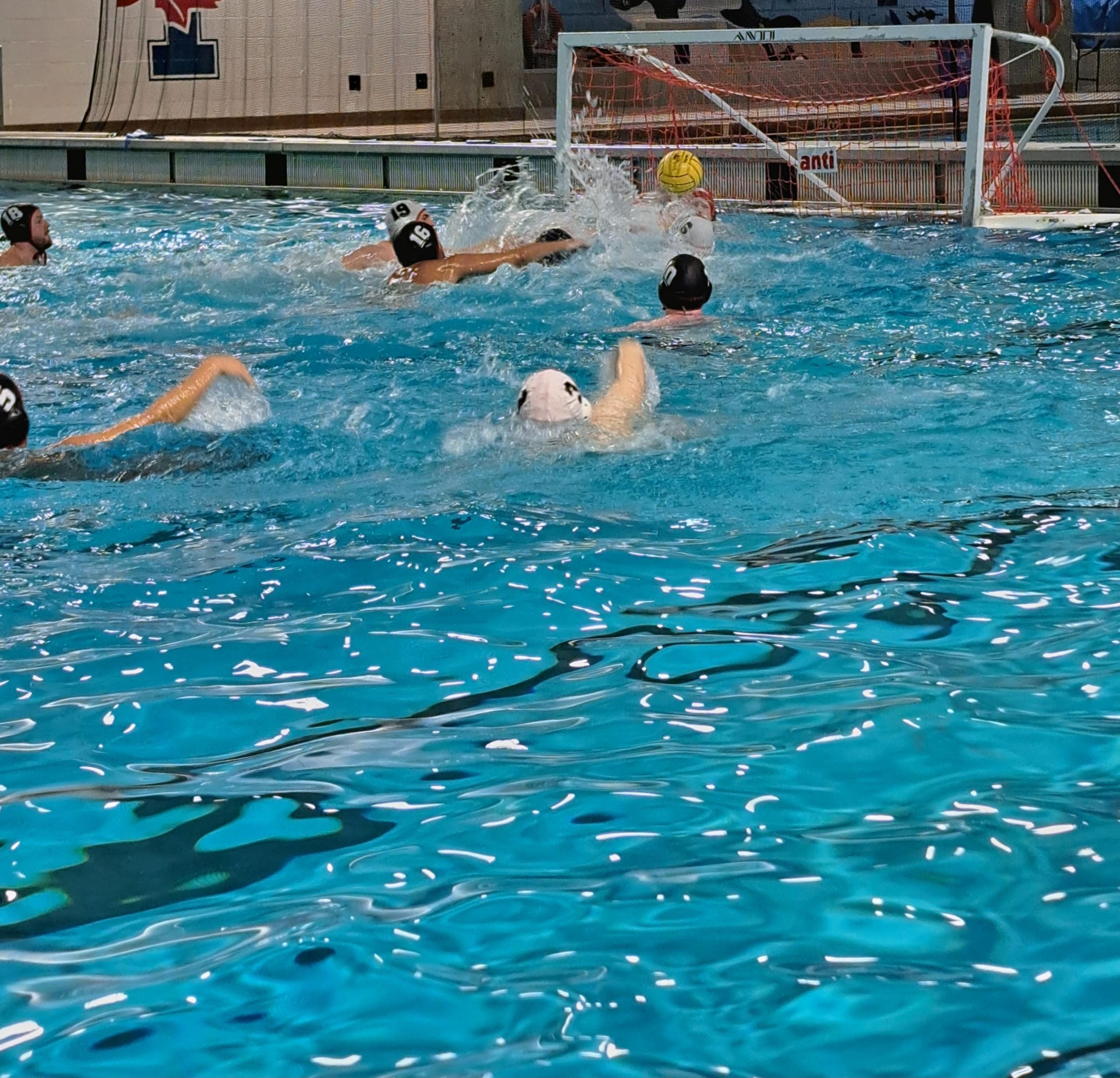 Des personnes jouent au water-polo dans une piscine intérieure. Des personnes jouent au water-polo dans une piscine intérieure.