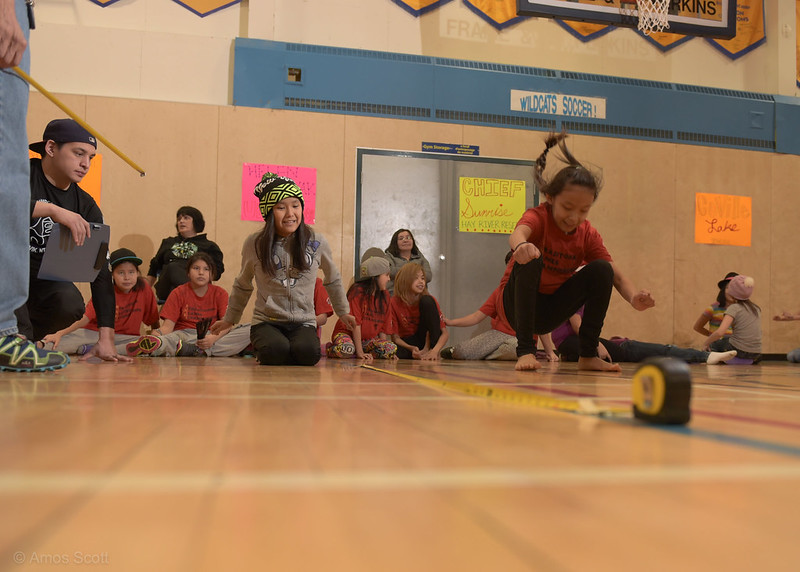 De jeunes filles participent au jeu inuit du saut groupé dans un gymnase. De jeunes filles participent au jeu inuit du saut groupé dans un gymnase.