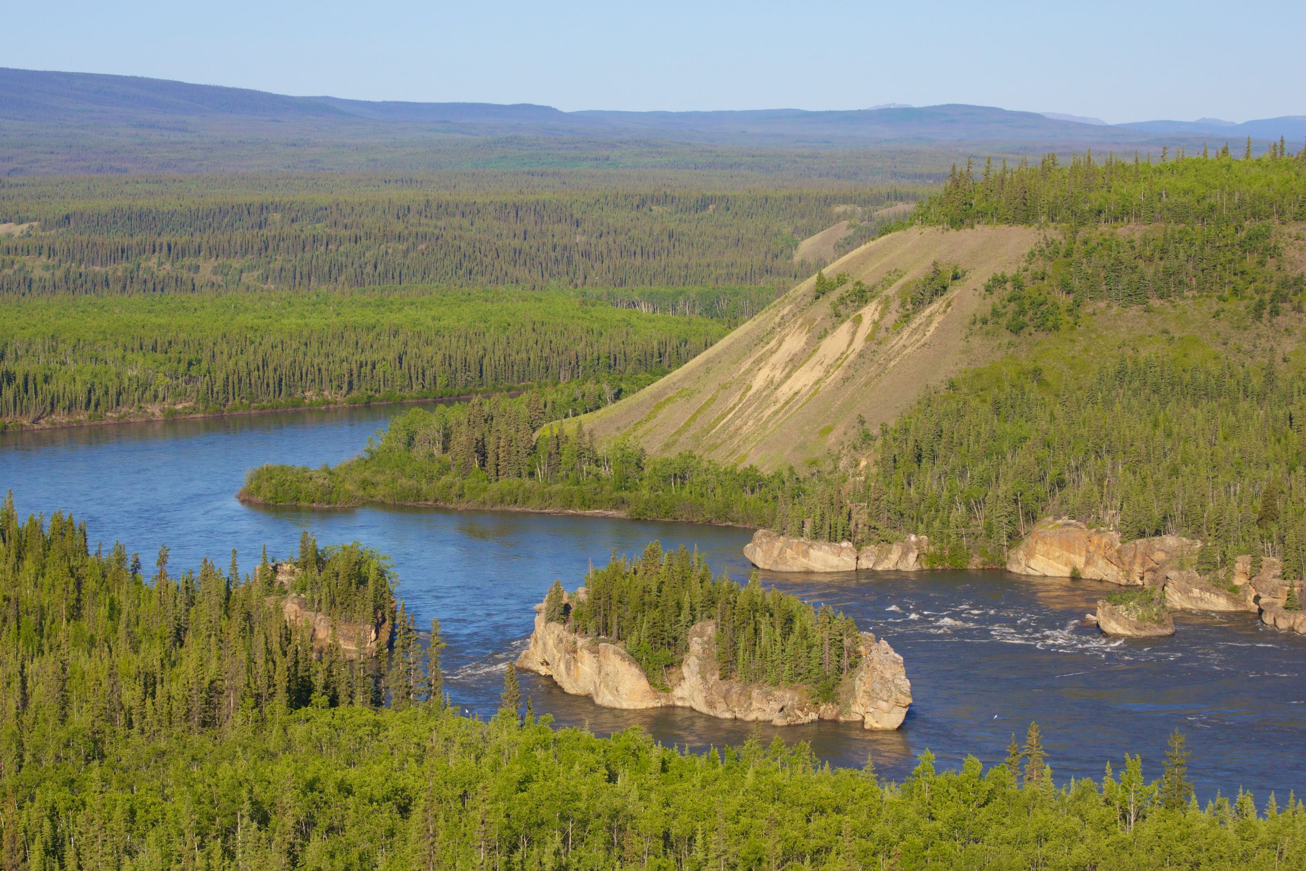 Une rivière entourée de montagnes et de forêt. Une rivière entourée de montagnes et de forêt.