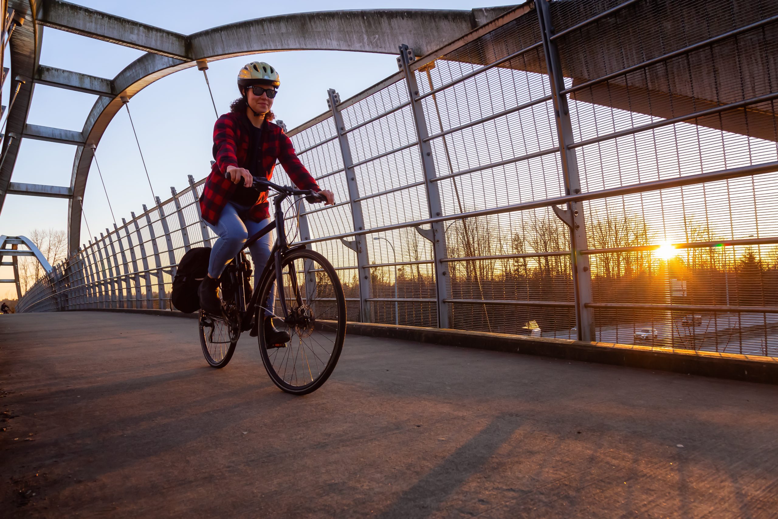 Une femme faisant du vélo sur un pont. Une femme faisant du vélo sur un pont.