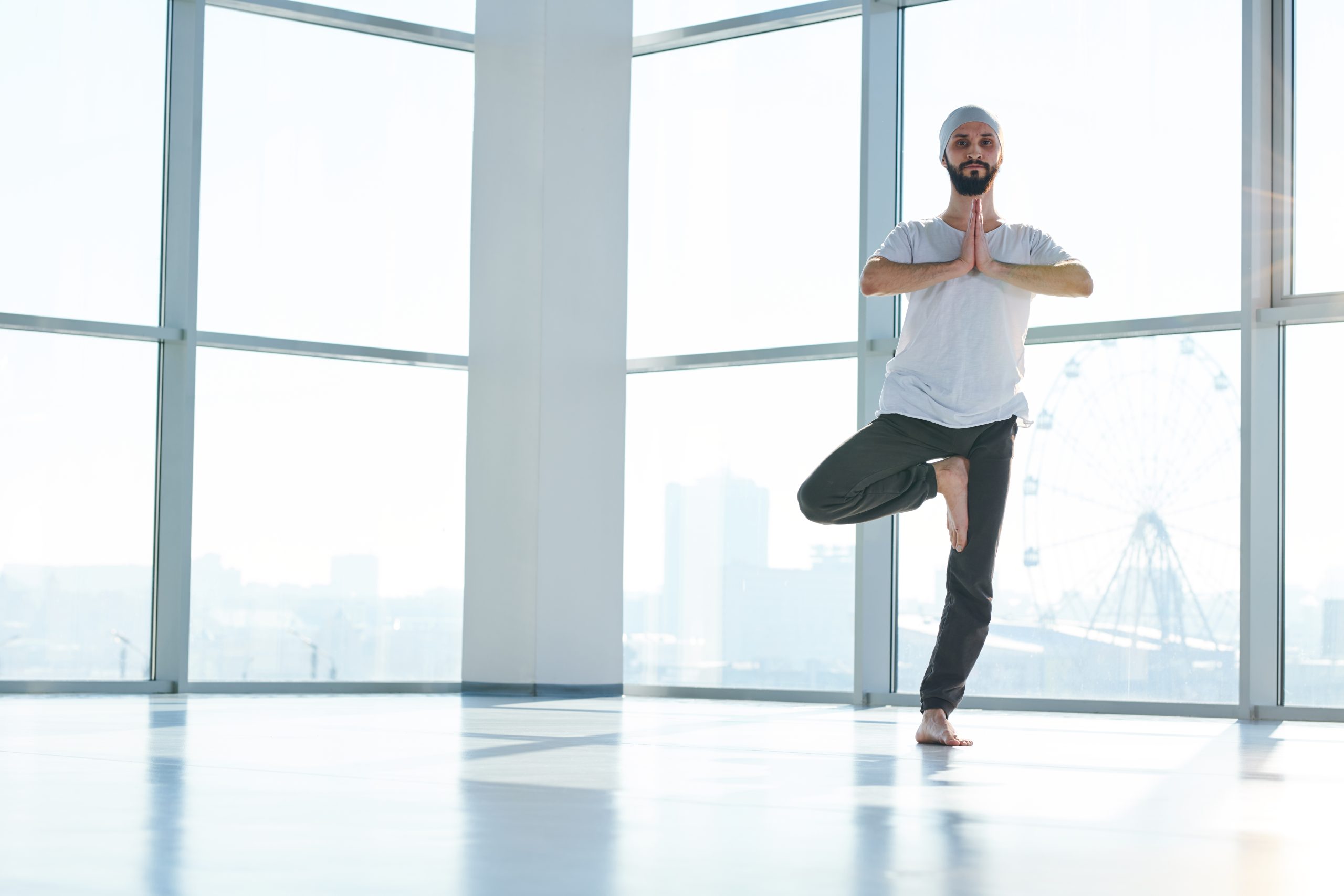 Un homme en posture de yoga sur une jambe. Un homme en posture de yoga sur une jambe.