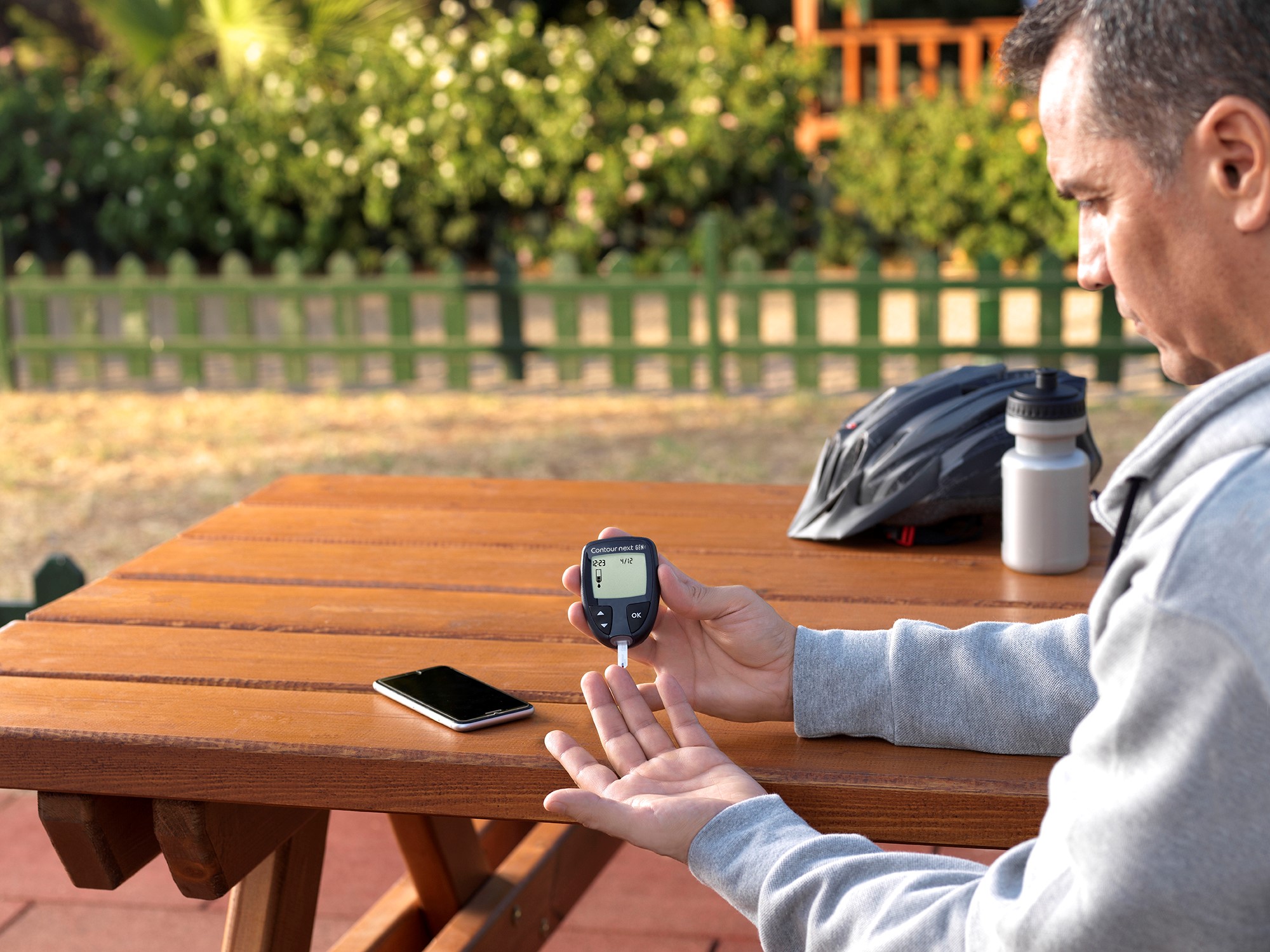 A man using a blood glucose meter. A man using a blood glucose meter.