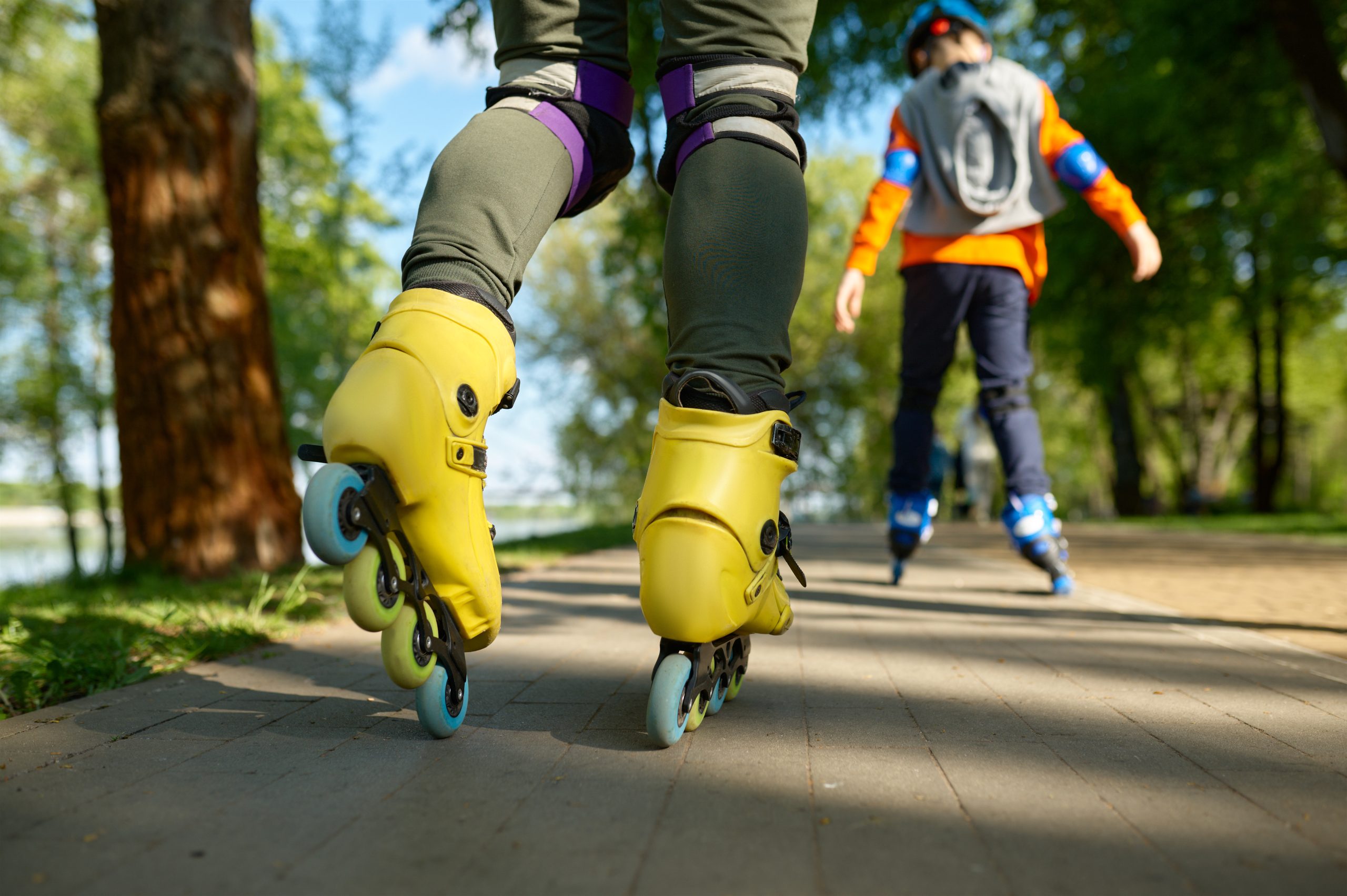 Deux personnes font du patin à roulettes sur un sentier de parc. Deux personnes font du patin à roulettes sur un sentier de parc.