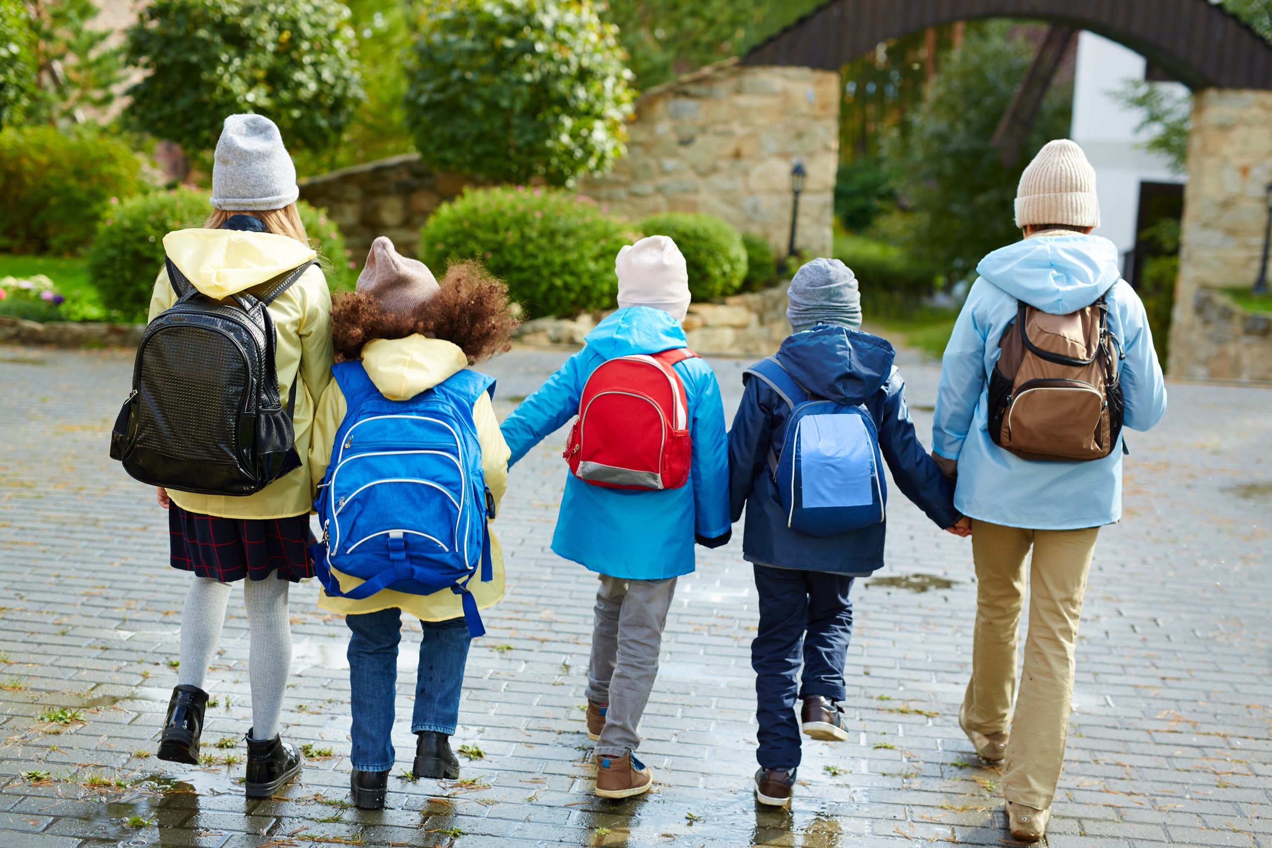 Un groupe d’enfants marche vers l’école en se tenant par la main. Un groupe d’enfants marche vers l’école en se tenant par la main.