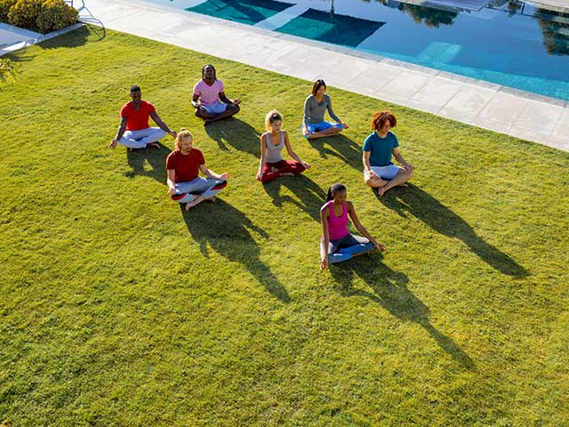 group of diverse friends doing yoga and meditating on grass group of diverse friends doing yoga and meditatingon grass