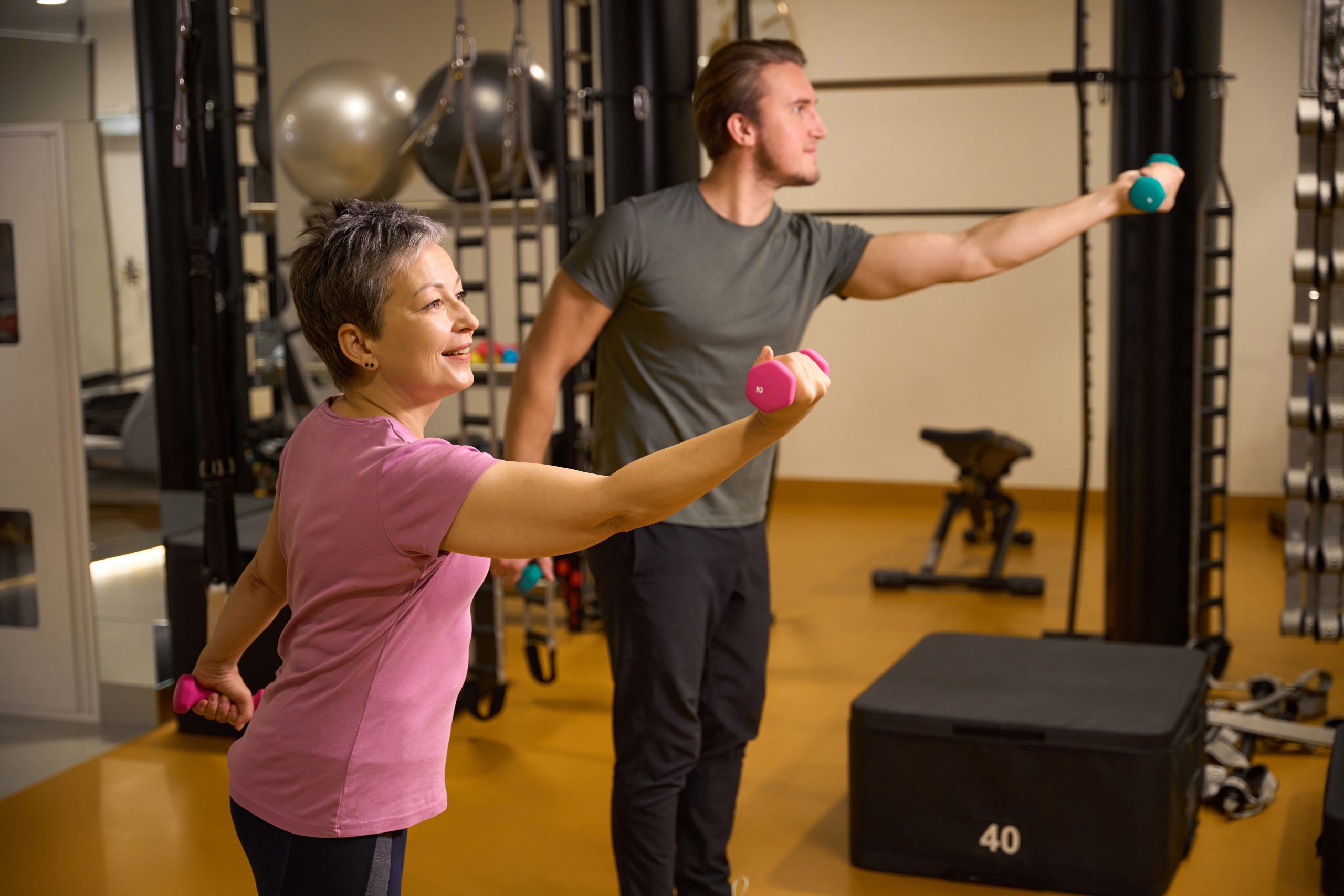 Un homme et une femme soulèvent des haltères dans un gym Un homme et une femme soulèvent des haltères dans un gym