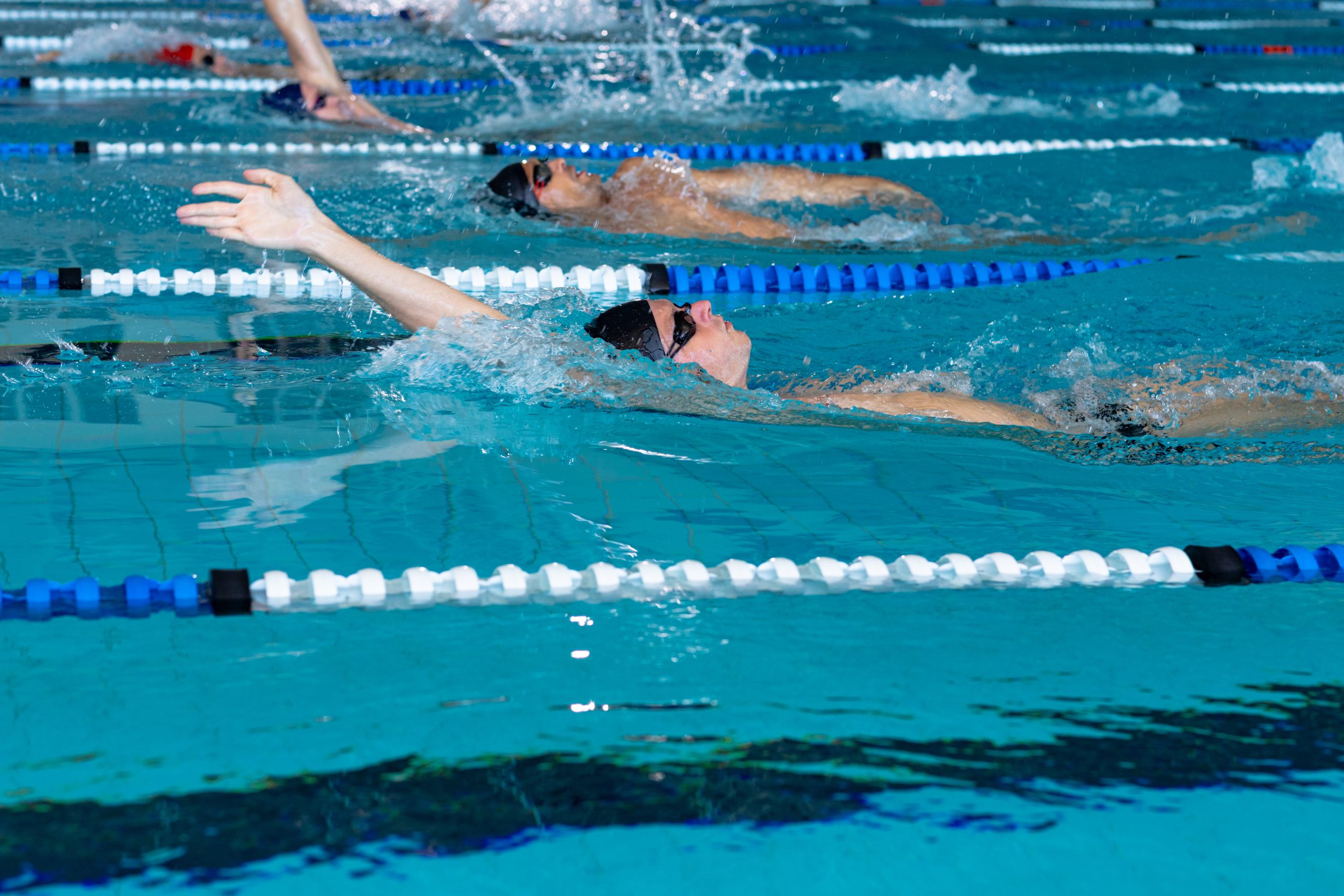 Un groupe de personnes nage dans une piscine. Un groupe de personnes nage dans une piscine.