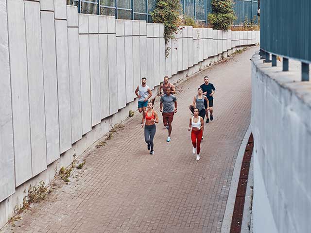 top view of a group of people running down a path together top view of a group of people running down a path together
