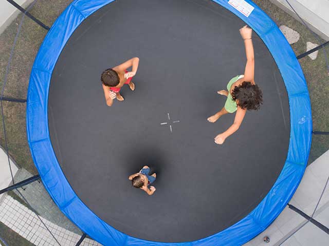 overhead view of children jumping on a trampoline overhead view of children jumping on a trampoline