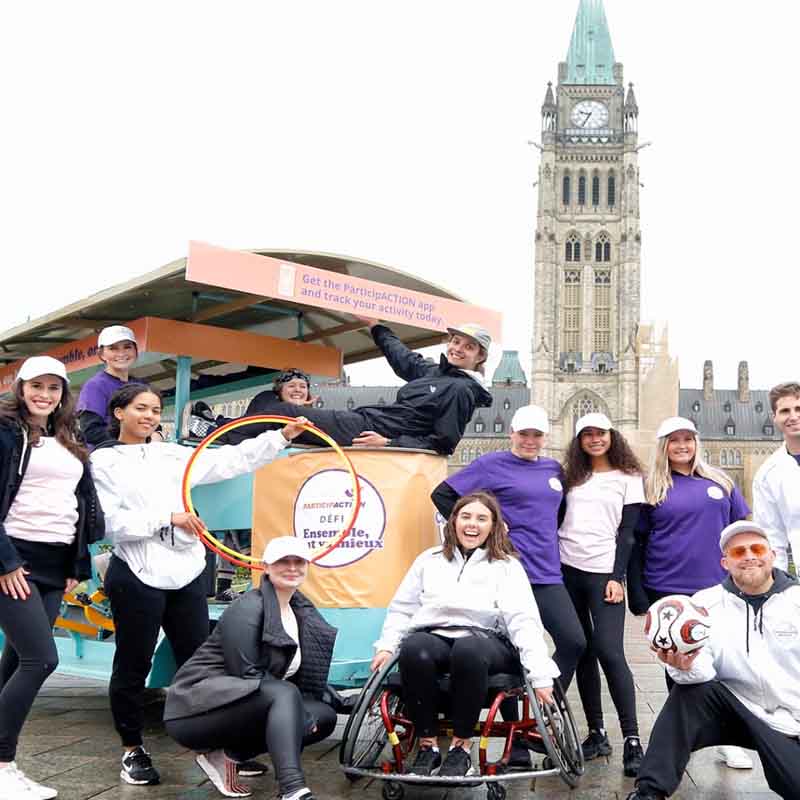 picture of diverse group of people with ParticipACTION posters in front of parliament hill picture of diverse group of people with ParticipACTION posters in front of parliament hill