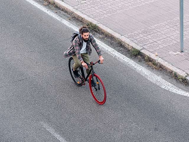 overhead view of a man biking on a street overhead view of a man biking on a street