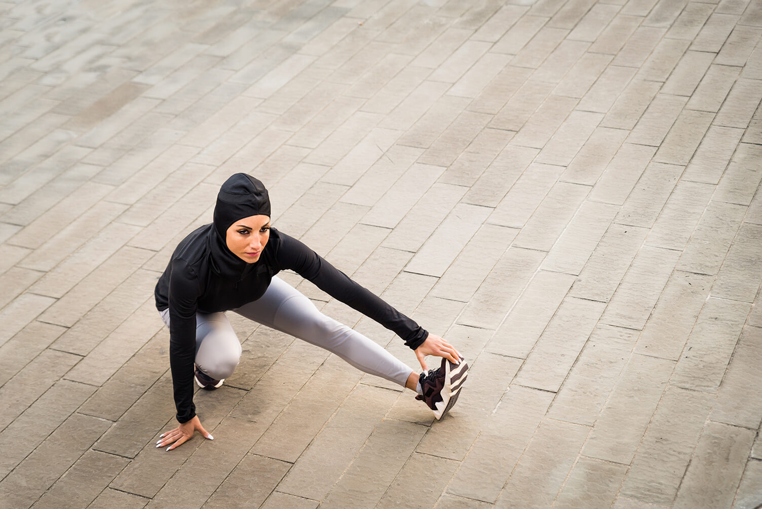 A young woman stretching on the pavement A young woman stretching on the pavement