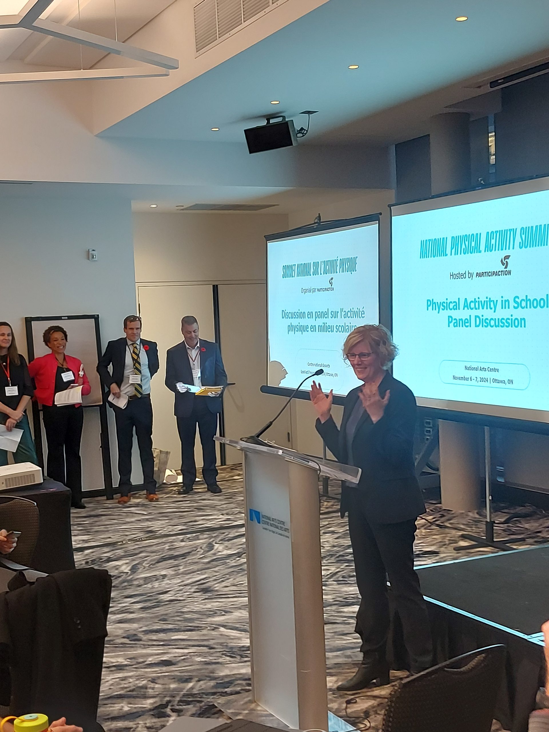 Minister Qualtrough speaking in front of a podium at the national physical activity summit. Minister Qualtrough speaking in front of a podium at the national physical activity summit.