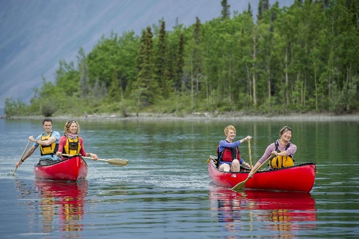 A group of people canoeing on a river. A group of people canoeing on a river.