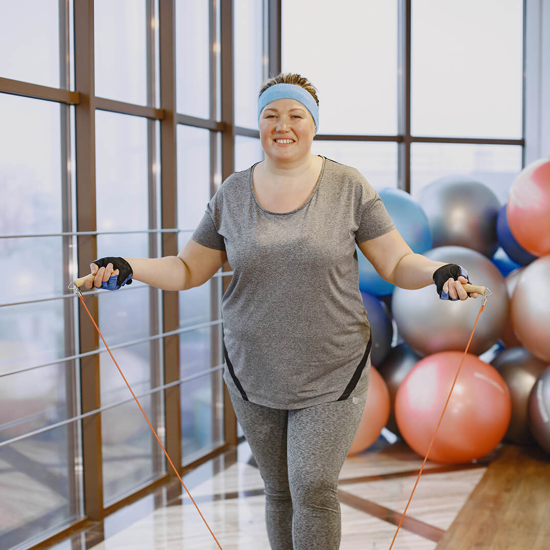 Une femme fait de la corde à sauter dans un gym.