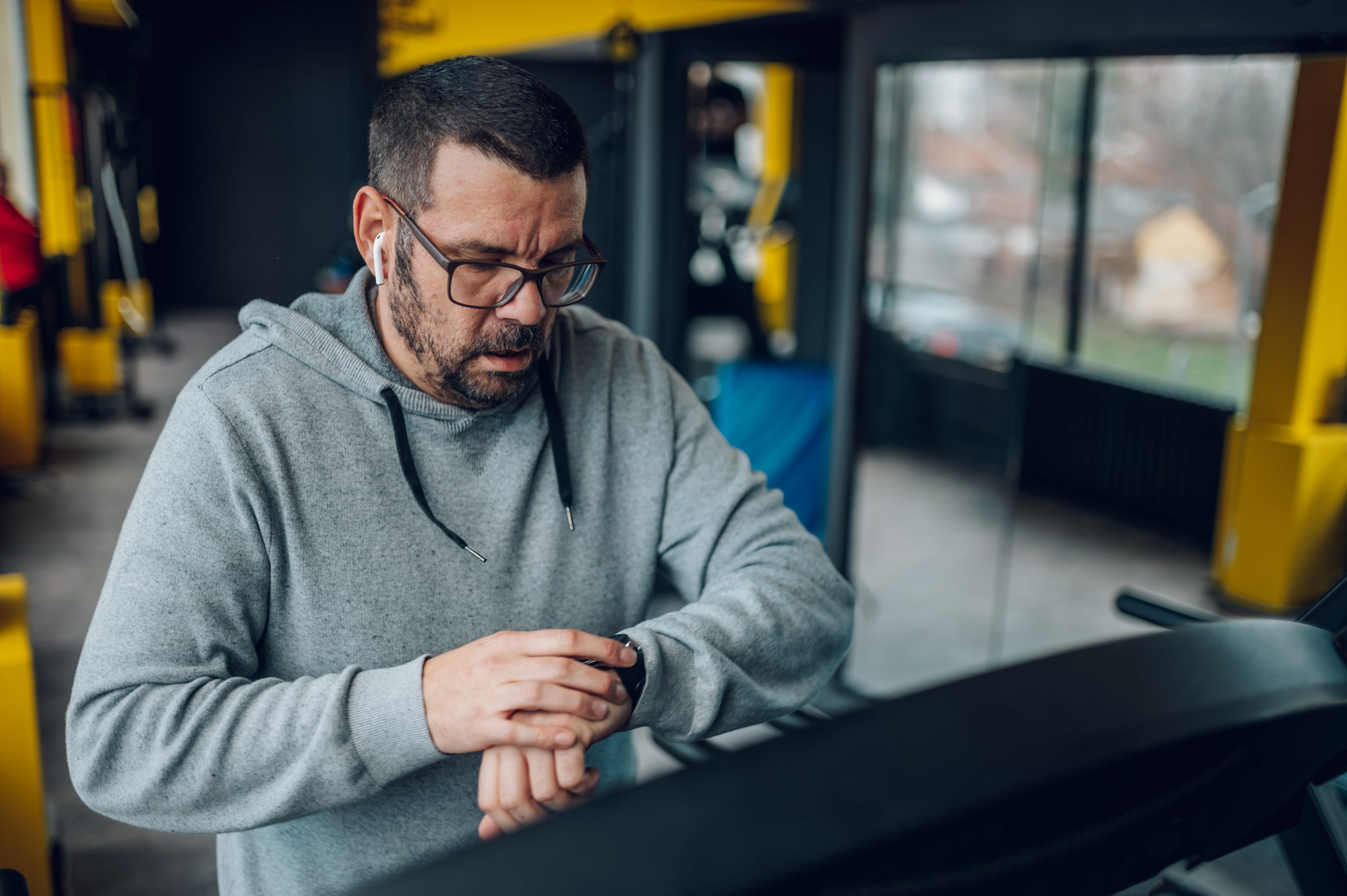Un homme sur un tapis roulant consulte son moniteur d’activités sur son poignet. Un homme sur un tapis roulant consulte son moniteur d’activités sur son poignet.