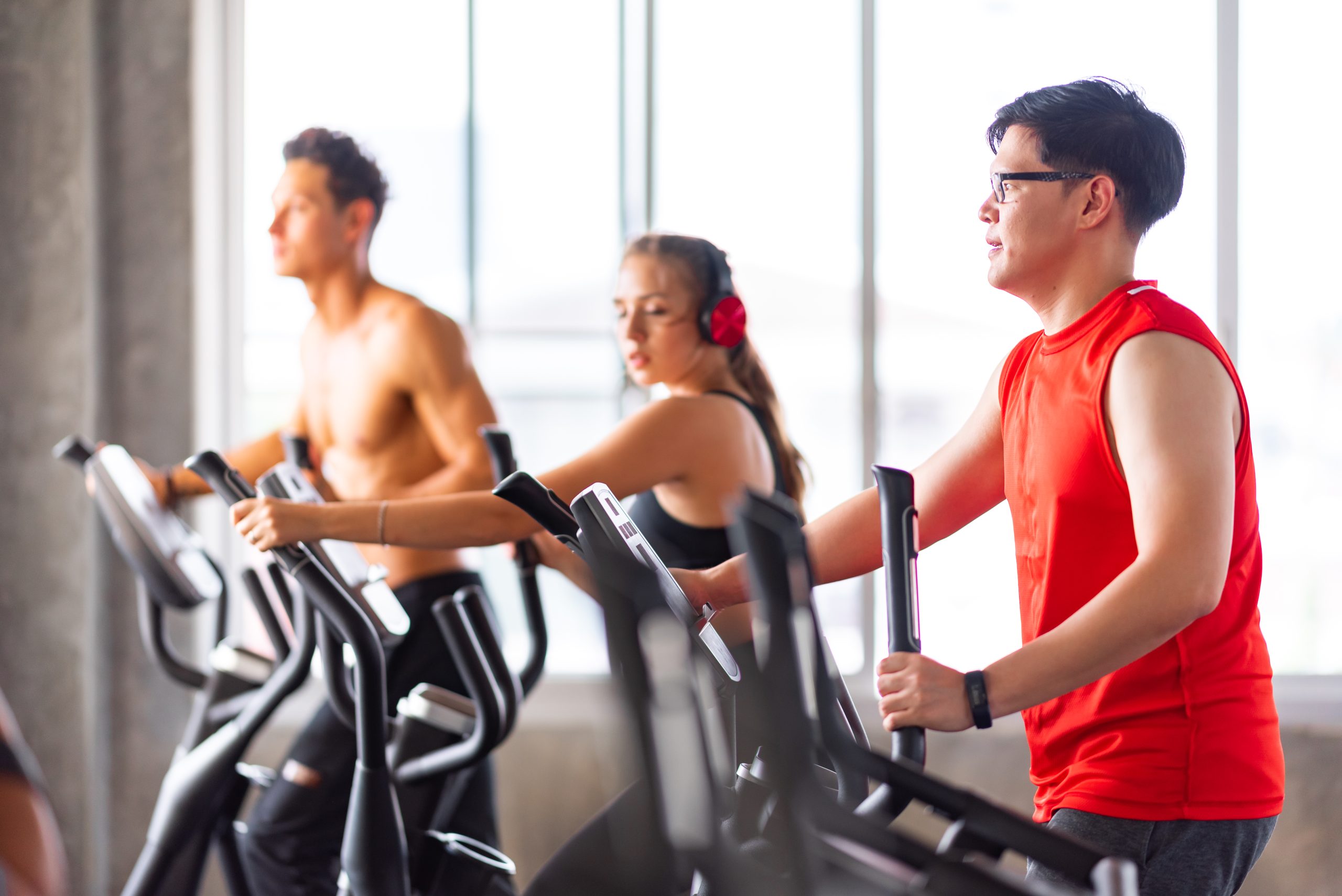 Un groupe de personnes utilisant des elliptiques dans un gymnase. Un groupe de personnes utilisant des elliptiques dans un gymnase.