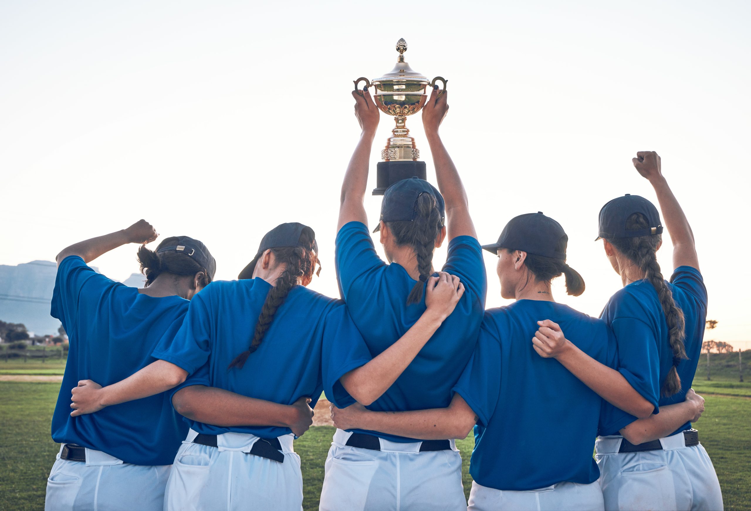 A group of female softball players holding up a trophy. A group of female softball players holding up a trophy.