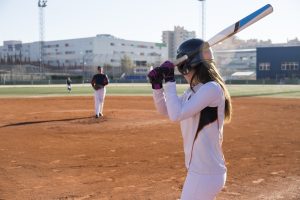 A woman getting ready to swing a softball bat on a softball field.