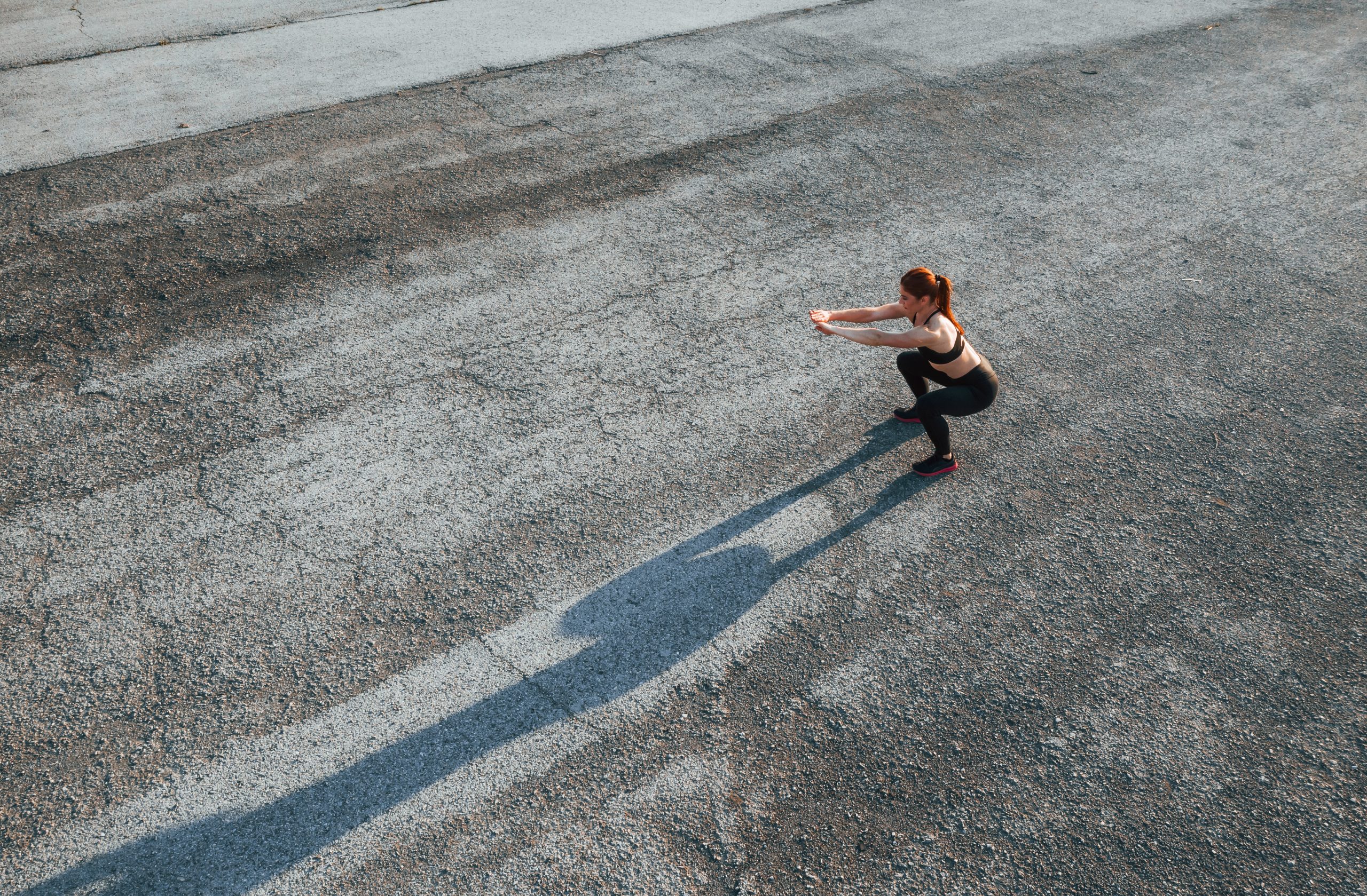 Une femme fait des squats sur la chaussée. Une femme fait des squats sur la chaussée.