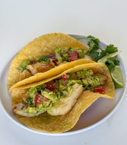 Two cod tacos on a plate.