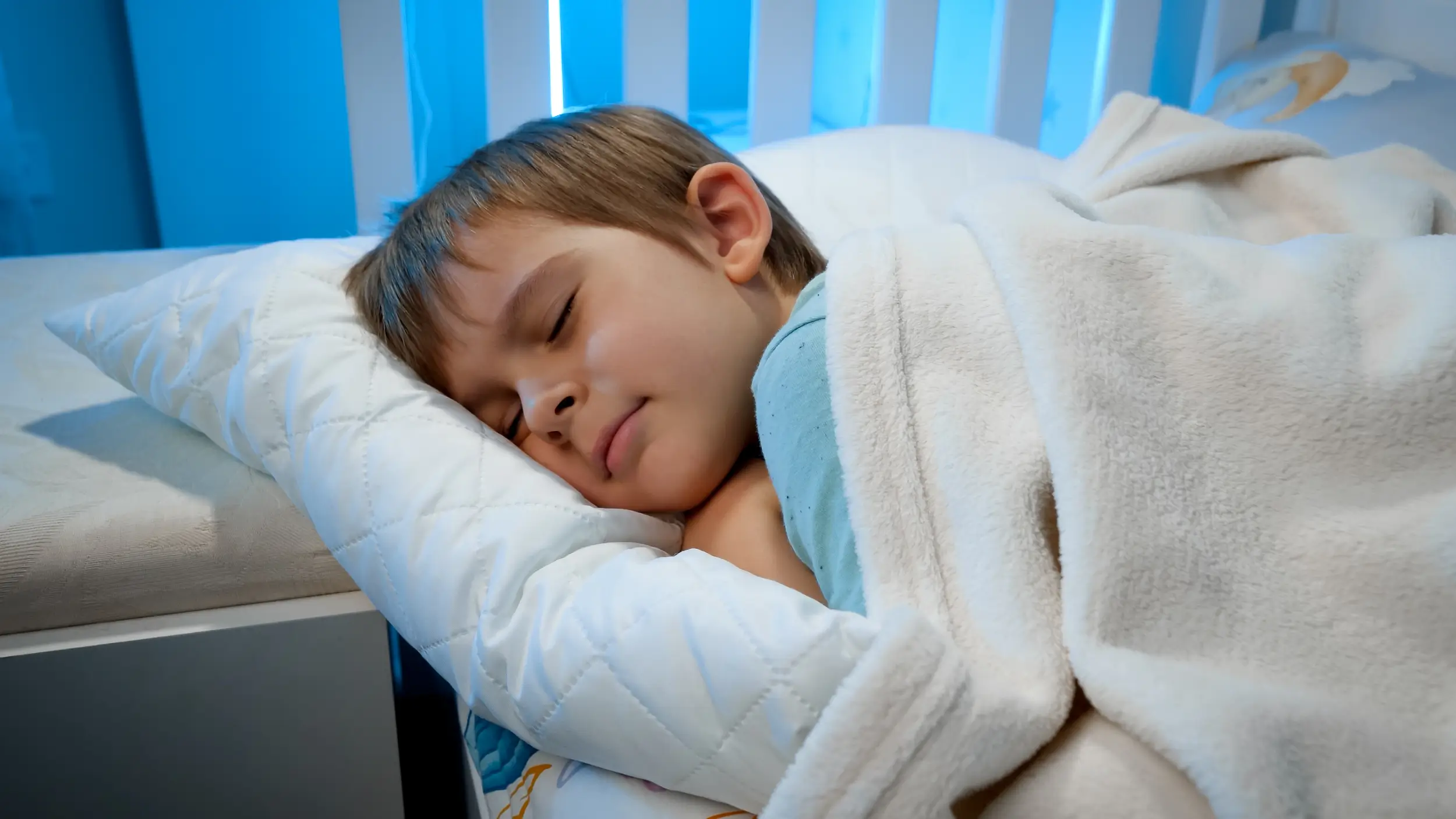 Un jeune garçon dort dans un lit. Un jeune garçon dort dans un lit.