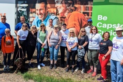 Des résidentes et résidents de Red Deer, en Alberta, se tiennent sur un terrain devant un panneau publicitaire. Des résidentes et résidents de Red Deer, en Alberta, se tiennent sur un terrain devant un panneau publicitaire.