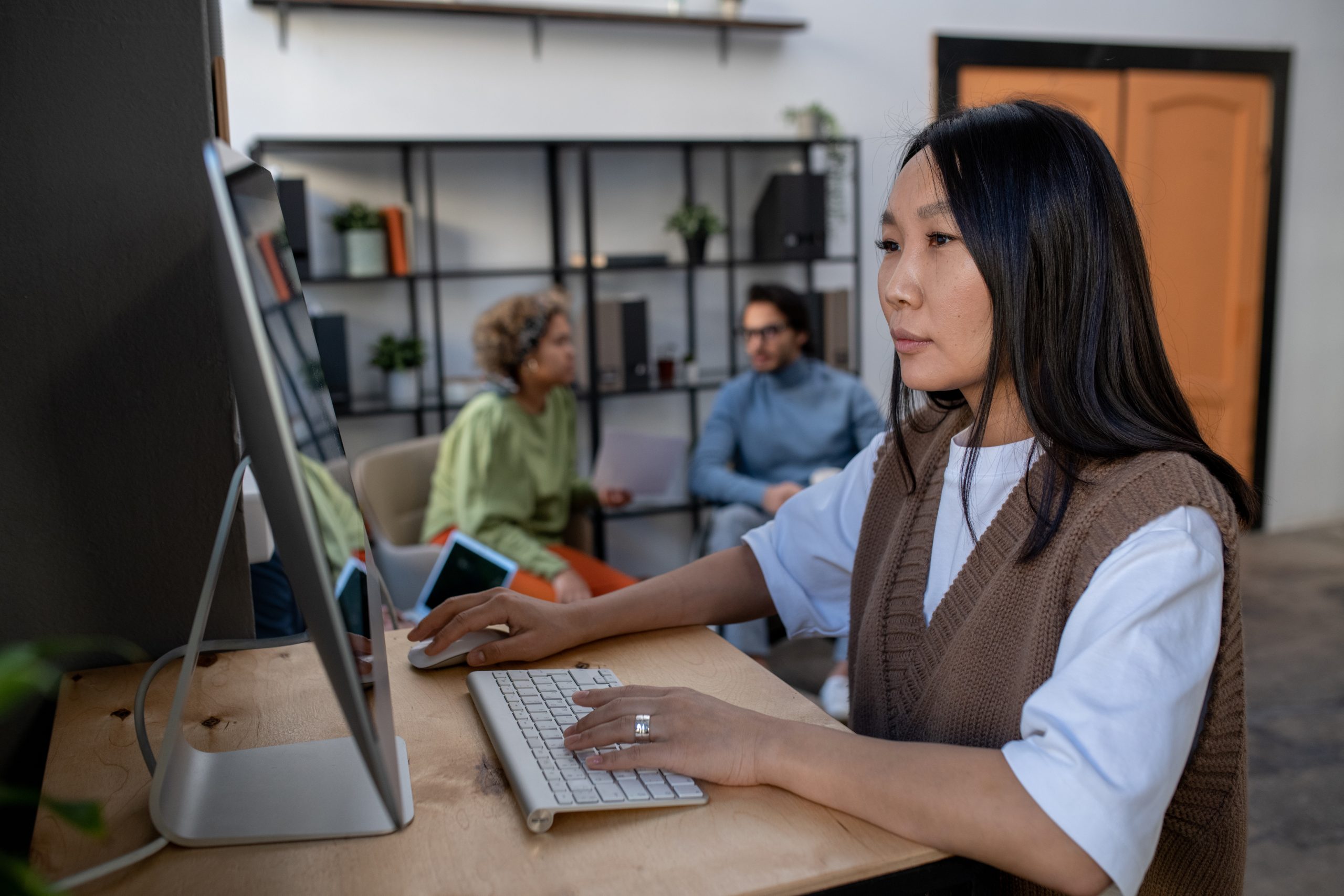 A woman working on a computer at a desk.  