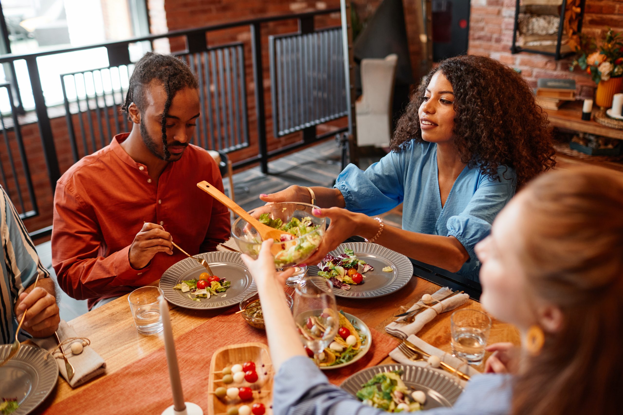 A group of people eating salad at a table. 