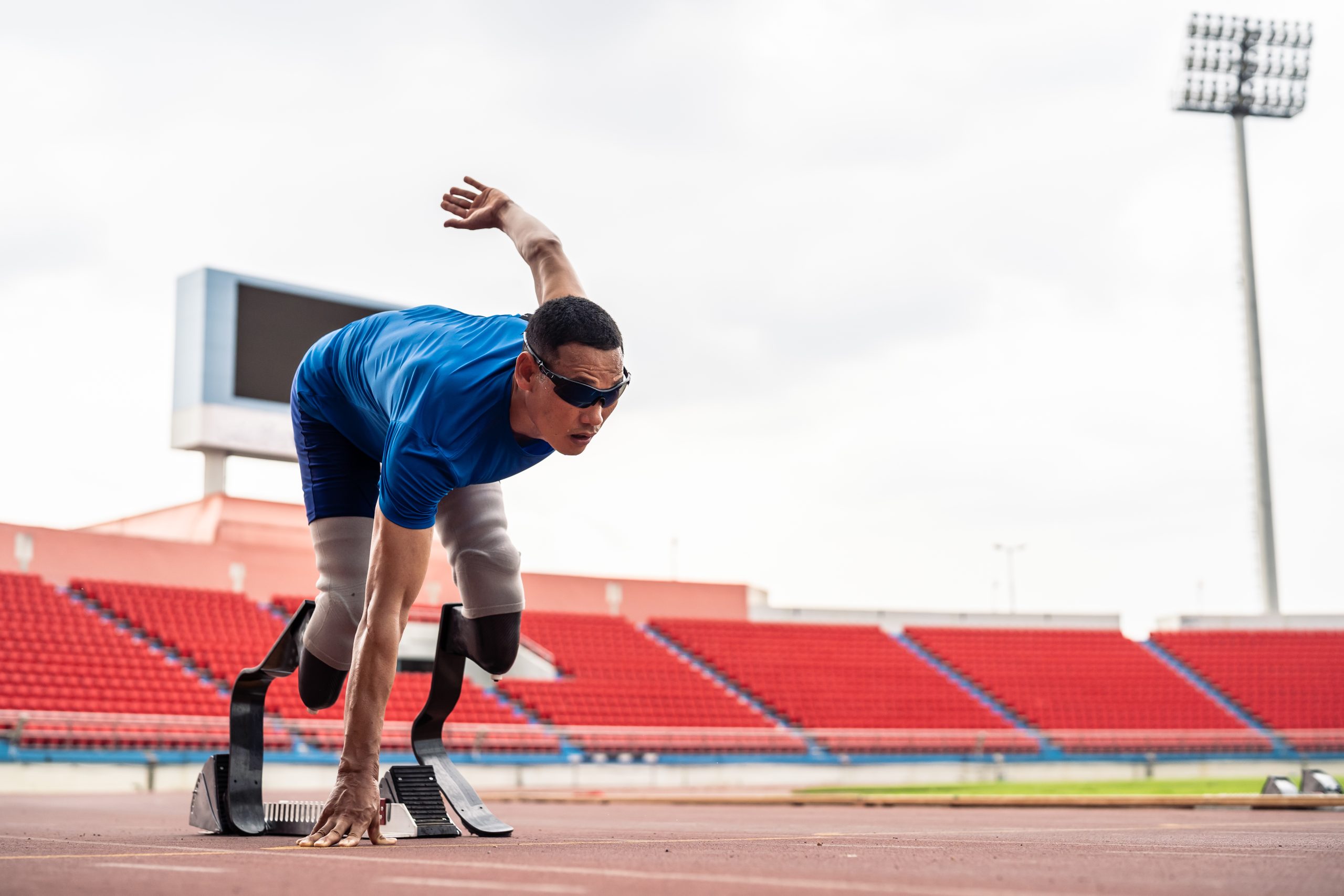 A man on a starting block on an outdoor track.