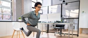 Une femme exécute des fentes dans un bureau.